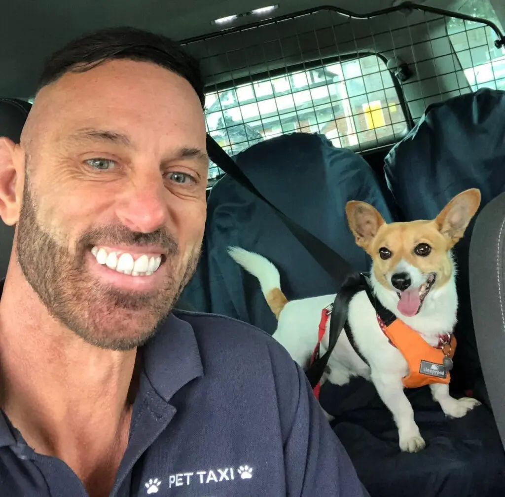 Pets 2 Places pet taxi driver smiling beside a securely harnessed dog, representing a rewarding pet franchise opportunity in the UK.