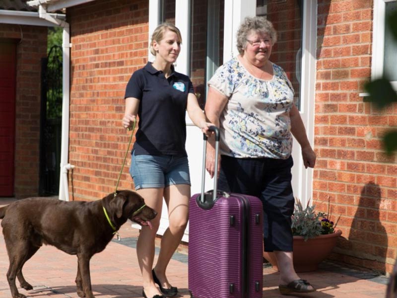 Pets 2 Places pet transport service helping an owner and her dog with luggage collection before travelling.